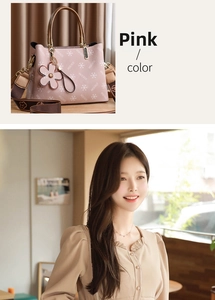 Pink printed tote bag with metal handles and wide shoulder strap shown on model