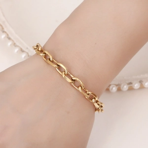 Bracelet chaîne minimalist en acier inoxydable doré pour femme sur un plateau de perles