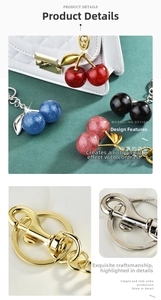 Detail of colorful cherry keychains with gold metal lobster clasps on a leather bag