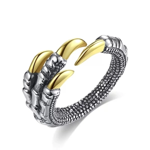 Close-up of vintage dragon claw ring with silver scales and golden pointed talons