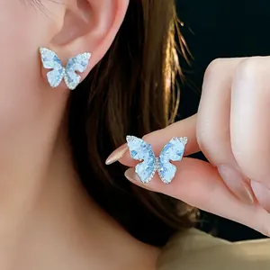 Boucles d'oreilles papillon élégantes avec texture bleue et zircons sur tige argent
