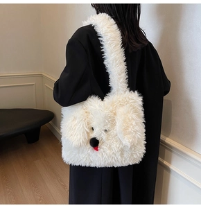 Detail of white plush dog-shaped tote bag worn by a model in a black winter coat
