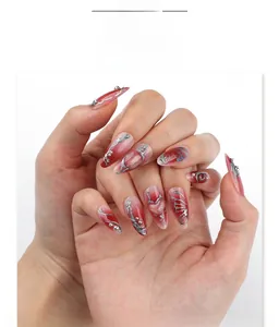 Detail of red gradient almond press-on nails with silver relief and pearl accents
