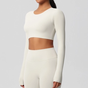 Détail de l'ensemble de yoga crème avec crop top manches longues et legging taille haute