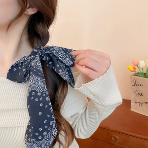 Detailed view of navy blue floral silk scarf tied as a bow in a braided hairstyle