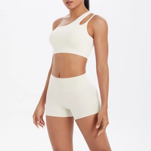 Detail of cream white one-shoulder sports bra and high-waisted shorts set for yoga