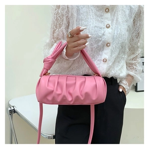 Detailed view of pink ruched cloud bag featuring knot handle and golden hardware