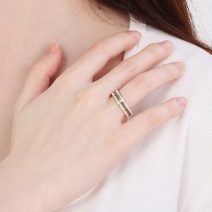Detailed view of dual-tone layered ring with sparkling crystals and gold rope design