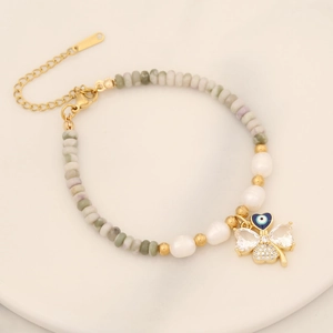 Detail of multi-color beads, pearls, and clover pendant with heart-shaped evil eye and zircons