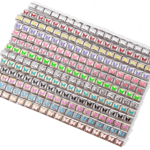 Macro view of stainless steel butterfly charms for modular Italian bracelets in various colors