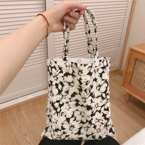 Detail view of floral canvas tote bag holding a tablet to show its interior capacity