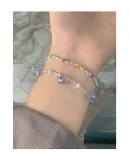Close-up of double-layer S925 silver bracelet with purple crystals and pearls on wrist