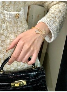 Detailed macro view of 18k gold iris open bangle with mother of pearl and pavé crystals