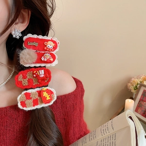 Détail de pinces à cheveux rouges du Nouvel An avec broderie Lucky et motifs festifs