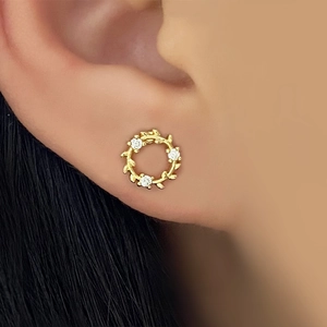 Elegant 18k gold plated wreath earrings with sparkling zircons shown on a model's ear