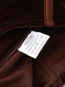 Detailed laundry care label showing 100% polyester composition on velvet fabric