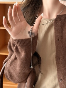 Detail showing a silver snake chain necklace with a 3D brown horse pendant and silver bead