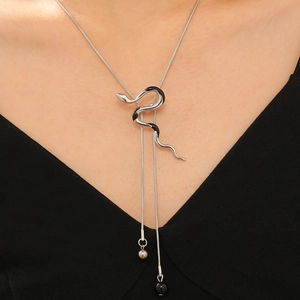 Silver snake pendant necklace with Y-chain and black bead details on model