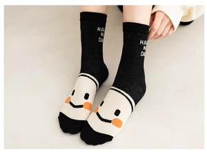 Detailed close-up of a black cotton sock with a white smiley face and HAVE A NICE DAY text