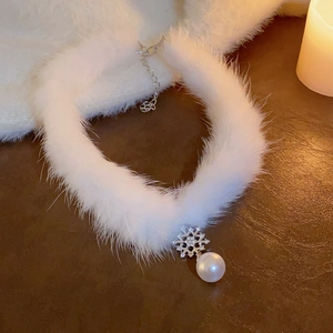 Détail d'un choker en peluche blanche avec pendentif flocon argenté et une grosse perle