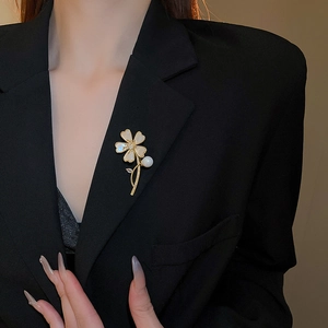 Détail d'une broche fleur avec pétales en nacre, cœur en zircon et perle pendante