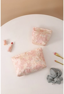 Detailed macro view of embossed floral lace cosmetic bags in large and small sizes