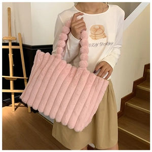 Detail of pink plush striped handbag with unique soft fuzzy ball handle design