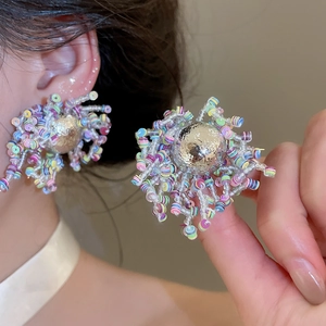 Primer plano de pendientes de flores con cuentas de colores en estilo dopamina vivo