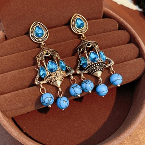 Detail view of vintage bohemian chandelier earrings with blue crystals in gold setting