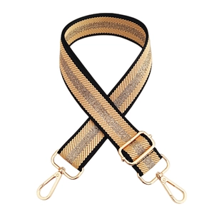 Detail of adjustable braided gold and black wide shoulder strap with metal lobster clasps