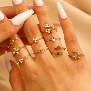 Close-up of gold zircon rings featuring butterfly and floral designs on satin