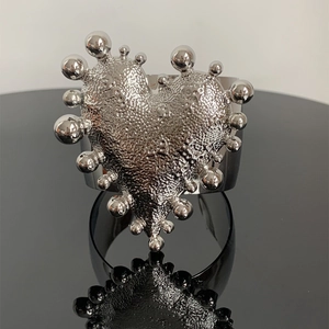 Detailed view of silver heart-shaped cuff bracelet with hammered texture and beaded edges