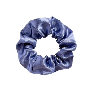 Detail of blue satin scrunchie showing glossy fabric texture and elegant pleats