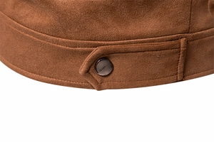 Detailed close-up of brown suede jacket showing classic engraved metal buckle on sleeve