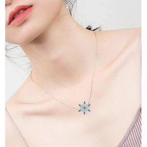 Silver snowflake necklace with blue gems and zircons shown on a female model