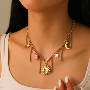 Gold celestial necklace with sun moon and star charms worn by model on a Cuban chain