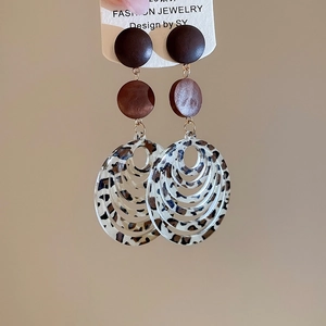 Detailed macro of leopard print resin and wood concentric circle drop earrings