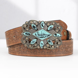 Detail of vintage brown leather belt with turquoise buckle and floral texture