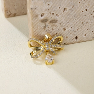 Exquisite gold bow pendant with zircon micro-paving and drop gemstone on a rock base