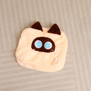 Detailed close-up of a square plush cat pillow case in beige with blue embroidered eyes