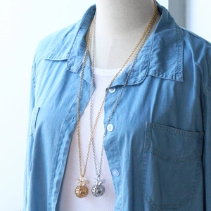 Détail du collier pendentif médaillon ananas en or et argent avec design ajouré