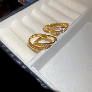 Close-up of 18k gold plated U-shaped earrings with zircons in a white velvet box