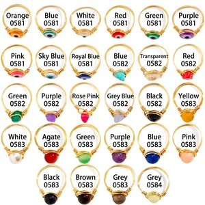Golden handmade wire-wrapped rings with evil eye charms and assorted gemstones in various colors