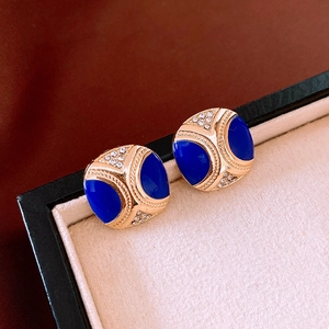Detail of vintage square earrings with dark blue enamel, gold finish, and rhinestones