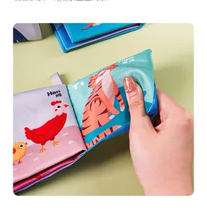 Detail of soft fabric baby book showing tiger and hen illustrations with crinkle texture