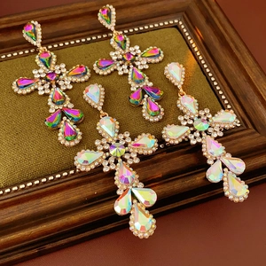 Detail of vintage baroque cross earrings with crystals on green velvet padding