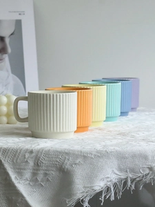 Detailed close-up showing six pastel colors and vertical stripes on ceramic mugs