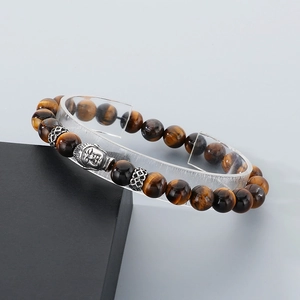 Detail of tiger eye stone beads with silver Buddha head on black jewelry box display