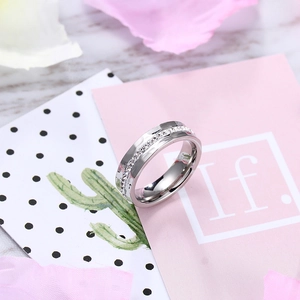 Close-up of silver titanium steel ring with sparkling crystals on a romantic pink floral set