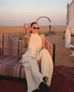 Chic beige pleated two-piece set featuring halter top and wide-leg pants in sunset desert